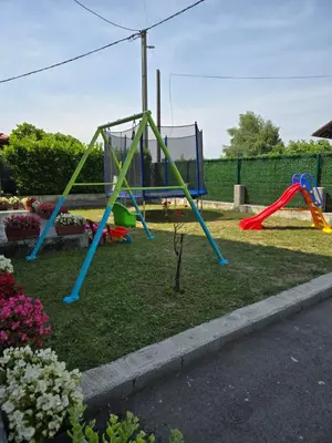 a playground with two swings in a yard at Apartman Nia in Bihać