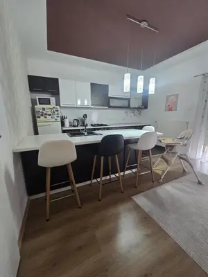 a kitchen with a table and chairs and a counter at Apartman Nia in Bihać