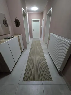 a hallway with a door and a carpet on the floor at Apartman Nia in Bihać
