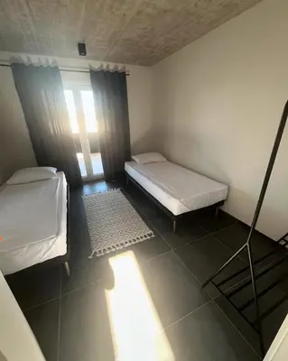 a small room with two beds and a window at Vila Trnovac in Bužim