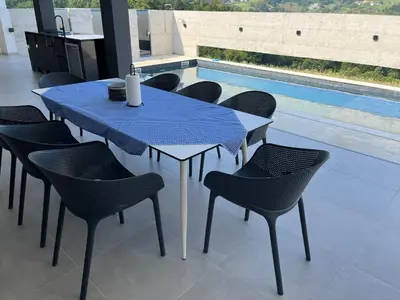 a blue table and chairs with a pool in the background at Vila Trnovac in Bužim