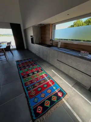 a rug on the floor in a room with a large window at Vila Trnovac in Bužim