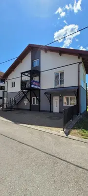a white building with a staircase on the side of it at Oz Lux Apartments in Bihać