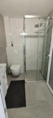 a bathroom with a glass shower and a toilet at Oz Lux Apartments in Bihać