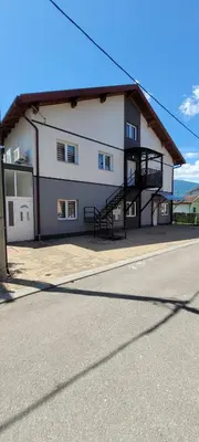 a large white building with a staircase in front of it at Oz Lux Apartments in Bihać