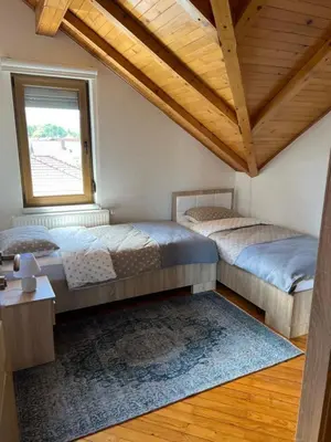 two beds in a room with a window at Teal Apartments in Bihać