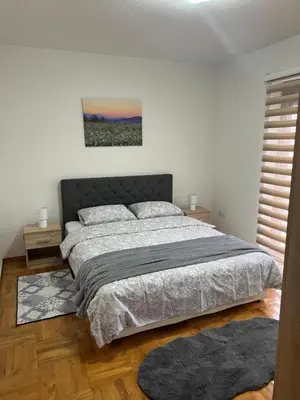 a bedroom with a large bed with two pillows at Teal Apartments in Bihać