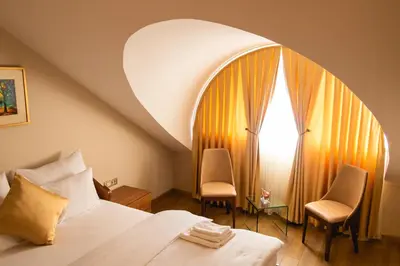 a hotel room with a bed and two chairs at Motel & Restoran Sunce in Busovača