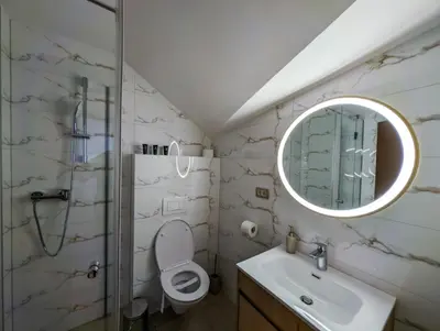 a bathroom with a toilet and a sink and a mirror at Motel & Restoran Sunce in Busovača