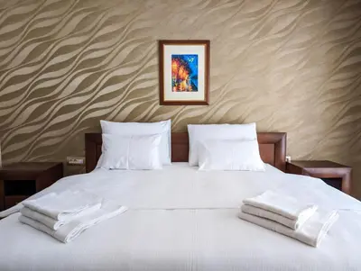a bed with white sheets and pillows on it at Motel & Restoran Sunce in Busovača