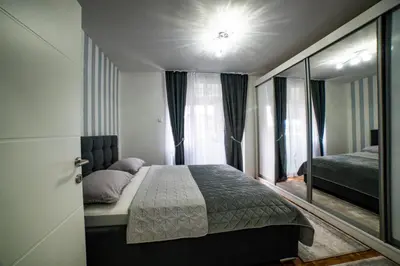 a bedroom with a bed and a large mirror at Lux Apartman Novi Grad in Bosanski Novi