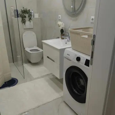 a bathroom with a washing machine and a toilet at Lux Apartman Novi Grad in Bosanski Novi