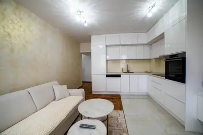 a living room with a white couch and a table at Lux Apartman Novi Grad in Bosanski Novi