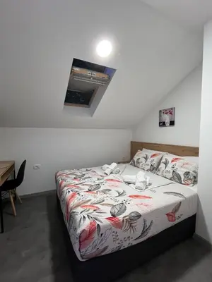 a small bedroom with a bed with avertisementatronatronstrationstration at Apartmani Venecia in Prozor