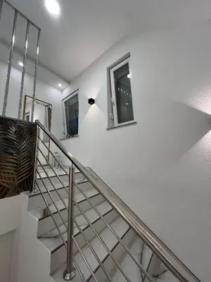 a stairway with white walls and a white stair railing at Apartmani Venecia in Prozor