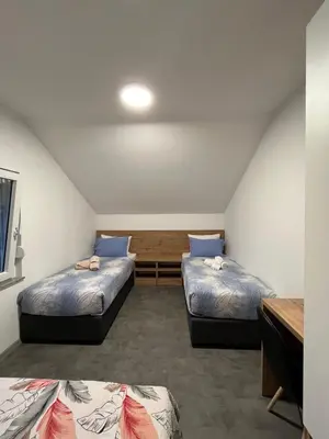 a room with two beds and a desk at Apartmani Venecia in Prozor