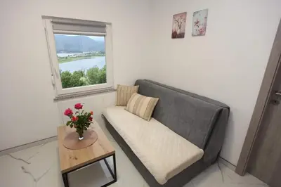 a living room with a couch and a table and a window at Apartmani Venecia in Prozor