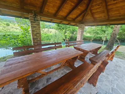 a wooden picnic table and benches in a pavilion at Villa Rivera in Banja Luka