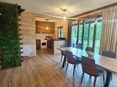 a kitchen and dining room with a wooden table and chairs at Villa Rivera in Banja Luka