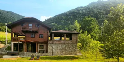 a house in a field with a mountain in the background at Villa Rivera in Banja Luka