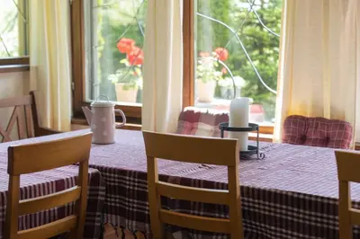 a table with two chairs and a table with a window at Vikendica Harun in Bihać