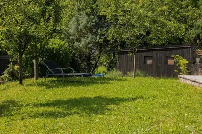 a chair sitting in the grass in a yard at Vikendica Harun in Bihać