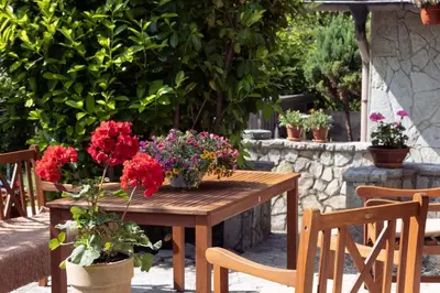 a wooden table with flowers on a patio at Vikendica Harun in Bihać