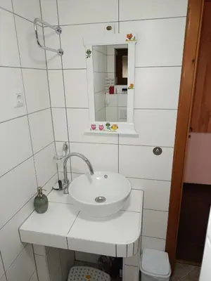 a white bathroom with a sink and a mirror at Vikendica Harun in Bihać