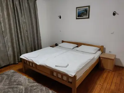 a bedroom with a large bed with white sheets at Luni in Travnik