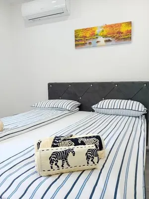 a bedroom with two beds with zebra pillows on them at Apartman Edwin Jajce in Jajce