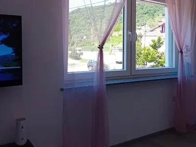 a window with pink curtains in a room at Apartman Edwin Jajce in Jajce