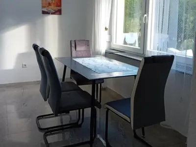 a dining room table with two chairs and a window at Apartman Edwin Jajce in Jajce
