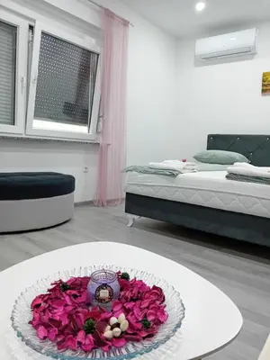 a room with a table with a bouquet of flowers at Apartman Edwin Jajce in Jajce