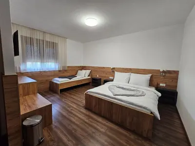 a bedroom with two beds and a television in it at Hostel PREMIUM in Derventa