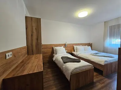 two beds in a room with wooden floors at Hostel PREMIUM in Derventa