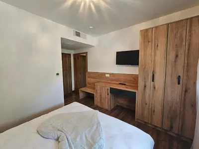 a bedroom with a bed and a flat screen tv at Hostel PREMIUM in Derventa