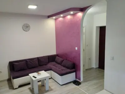 a living room with a purple couch and a table at Apartman Central in Doboj