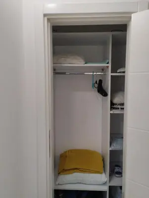 a small closet with a yellow towel on the shelves at Apartman Central in Doboj