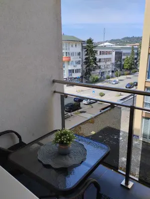 a table on a balcony with a view of a street at Apartman Central in Doboj