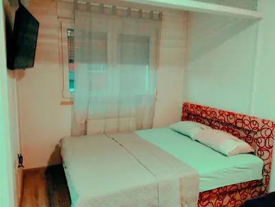 a bedroom with a bed and a window at Apartman Central in Doboj