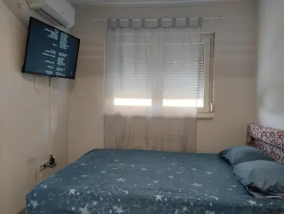 a small bedroom with a bed and a window at Apartman Central in Doboj