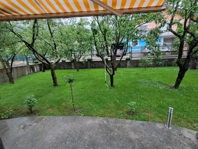 a yard with trees and grass with an umbrella at Kuca za odmor Amber in Bihać
