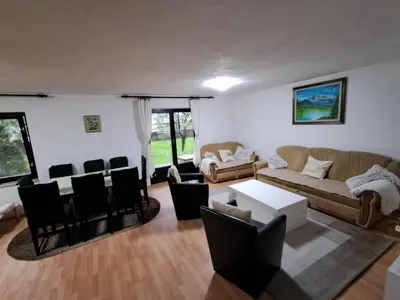 a living room with a couch and a table and chairs at Kuca za odmor Amber in Bihać