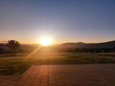 a sunset with the sun setting in a field at Antiva in Livno