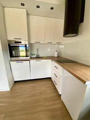 a white kitchen with white cabinets and a wooden floor at Antiva in Livno