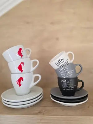two cups of coffee sitting on plates on a table at Apartmаn Avram ll in Kotor-Varoš