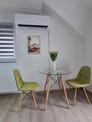 two chairs and a table with a vase of flowers at Apartmаn Avram ll in Kotor-Varoš