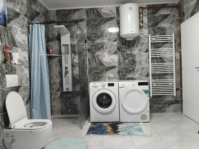 a bathroom with a washing machine and a toilet at Apartman Kenan in Bihać
