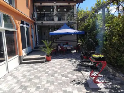 a patio with a blue umbrella and a table at Apartman Kenan in Bihać
