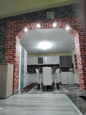 a kitchen with a brick wall and a table and chairs at Apartman Kenan in Bihać